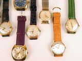 several different types of watches are displayed on a white surface