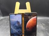 Deux téléphones portables sont posés sur un support en bois, sur une table.