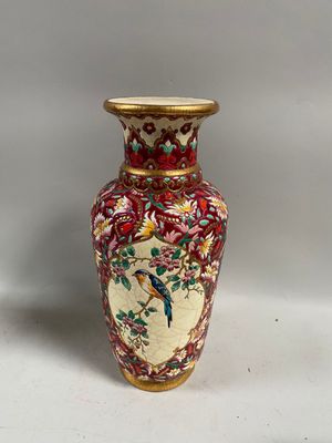 un vase avec un oiseau posé sur une table
