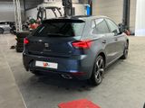 the rear end of a grey car parked in a garage