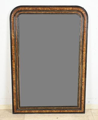 a large black and gold framed mirror sitting on top of a wooden floor
