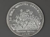 an old silver coin with a picture of a man riding a horse on it