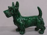 a small green dog figurine sitting on a table