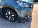 a green car that is parked on the side of the road