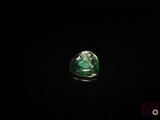 a close up of a green and white diamond on a black surface
