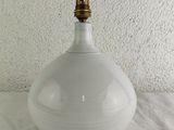 a white vase with a gold top sitting on a table