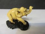 an elephant statue on a black base on a white table
