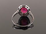 a close up view of a pink tourmaline ring on a black surface