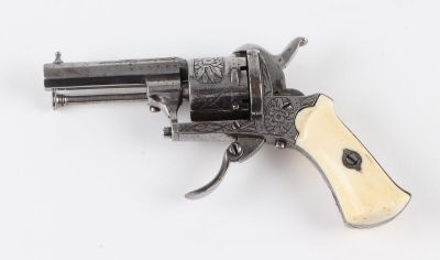 a close up of a revolver with a wooden handle on a white surface
