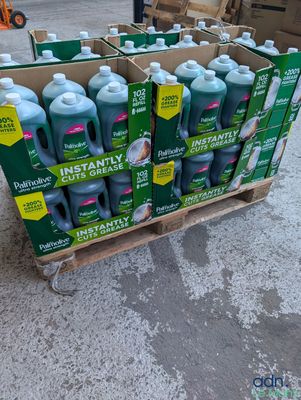 Plusieurs bouteilles de Deteré sont empilées sur une palette dans un parking.