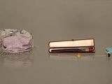 une petite boîte contenant un stylo et un petit sac muni d'un anneau