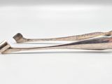 pair of silverware tonges on a white surface with a white background