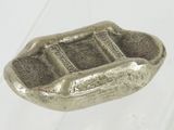un petit objet en argent posé sur une table