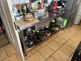 many pots and pans on the counter in this kitchen