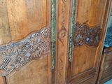 a wooden armoire with carvings on it in a room