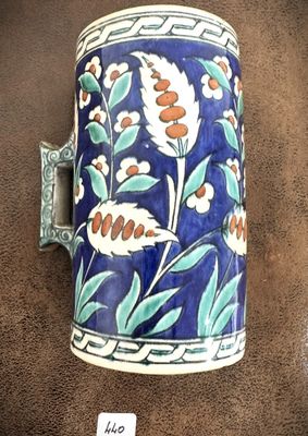 un vase bleu et blanc orné de fleurs, posé sur un support marron