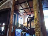 un miroir au milieu d'une pièce, avec un escalier en arrière-plan