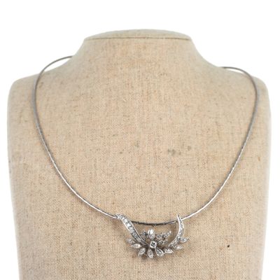 a silver necklace with a bird on it on a mannequin