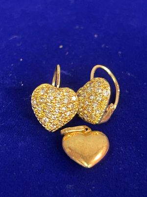 un gros plan sur une paire de boucles d'oreilles en forme de cœur posées sur une surface bleue