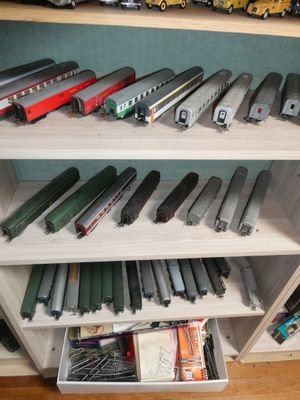 many toy trains sitting on a shelf in a room