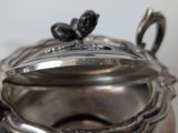 a silver tea pot with a lid on a table