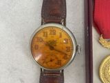 a watch that is sitting next to a medal
