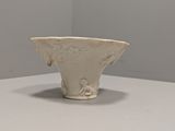 un vase blanc posé sur une table blanche dans une pièce