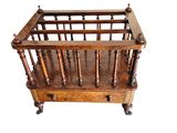 a small wooden crib with a magazine rack on top of it