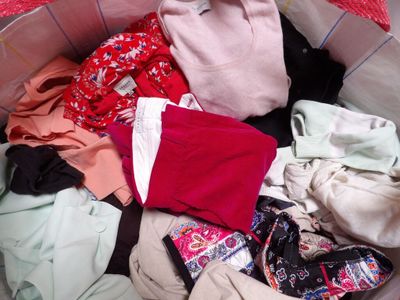 a basket full of clothes that is sitting on the floor
