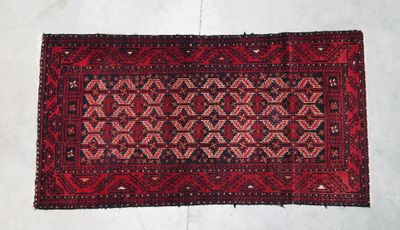 a close up of a red rug on a white floor