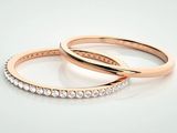 two rose gold wedding rings with diamonds on a white background