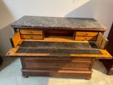 a wooden dresser with a marble top and drawers