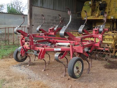 a picture of a tractor and a farm equipment in a barn