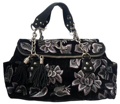 black and silver handbag with flowers and tassels on a white background