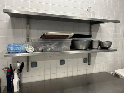 une étagère en métal avec des casseroles et des poêles