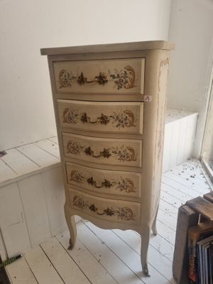 une petite commode dans le coin d'une pièce