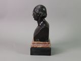 statue of a man with a black hair and a white shirt on a marble base