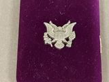a close up of a purple velvet case with a silver eagle on it