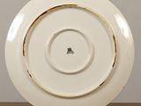 a white plate with a gold rim sitting on a table