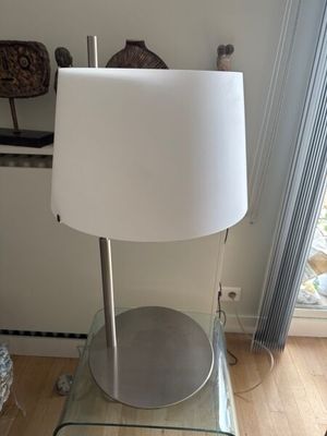 une table en verre sur laquelle est posée une lampe