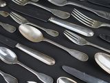 a lot of silver spoons and forks on a table