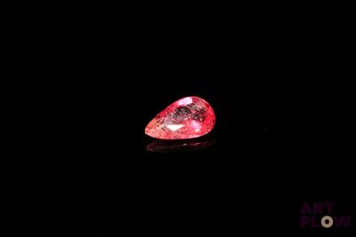 gros plan d'un diamant rose sur une surface noire