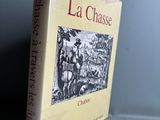 Le livre *La Chasse* est posé sur une table près d'un mur gris.