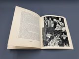 un livre ouvert sur lequel figure une photo en noir et blanc d'un groupe de personnes