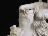 a statue of a woman holding a vase with flowers on it