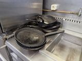pots and pans are on a stove in a commercial kitchen