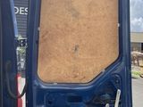 a blue van with the door open on the side of the road