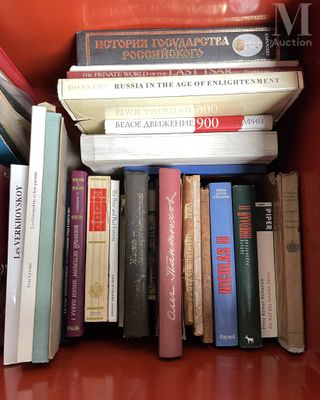 beaucoup de livres posés sur une chaise rouge
