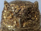 a gold owl figurine sitting on top of a table