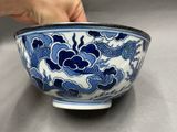 a person holding a blue and white bowl on a table